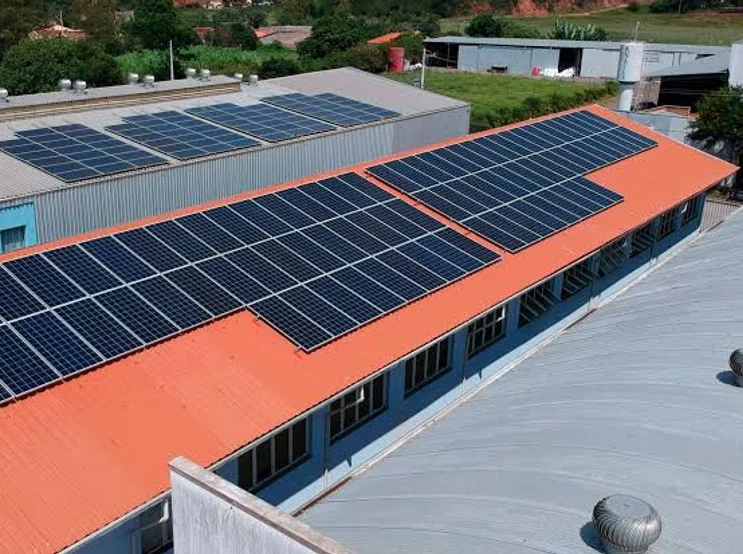 Telhado de galpão industrial coberto por duas fileiras de módulos solares